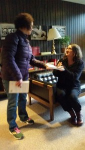 Author hands book to student